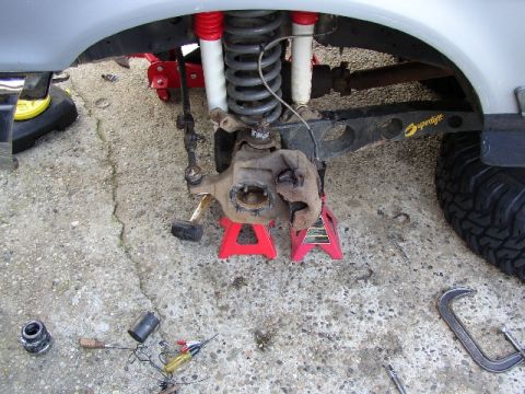 1989 Ford Bronco - Front suspension components of a 1989 Ford Bronco are visible while supported by jack stands.
