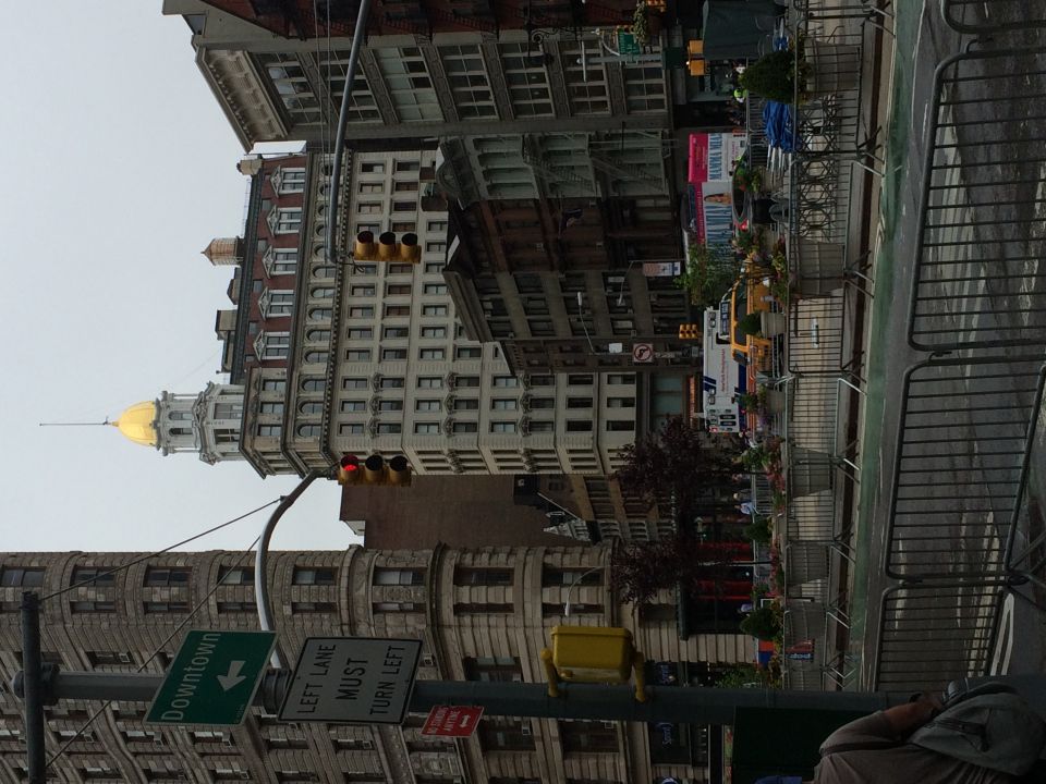 Street view of the Flatiron district with traffic signals and a domed building in New York City
