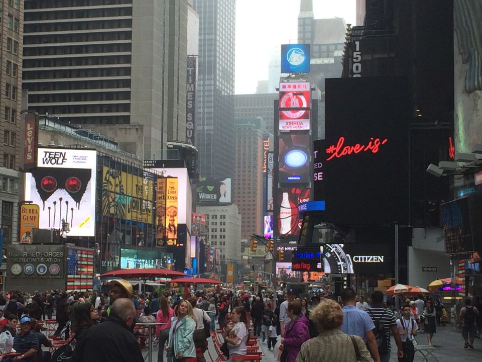 Crowded Times Square with illuminated billboards and theater marquees
