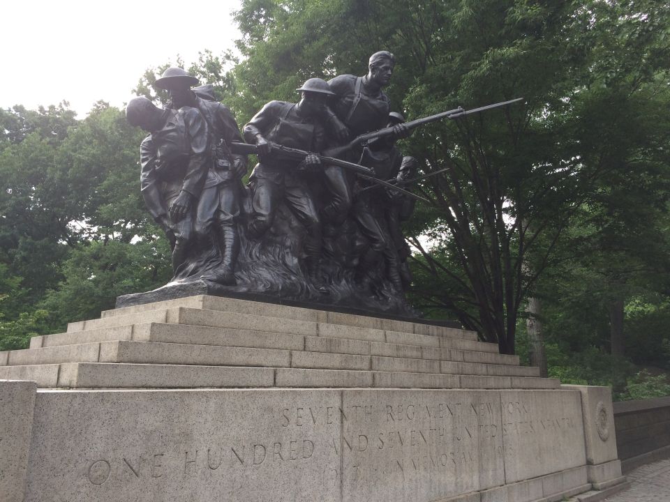 Bronze WWI soldier monument on a stone base in a park