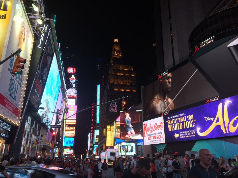 Times Square at night with bright billboards and crowds of people