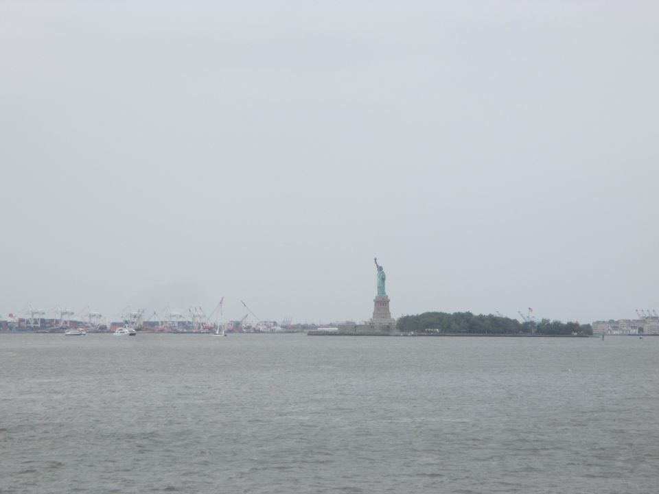 Statue of Liberty and New York Harbor with ships and cranes