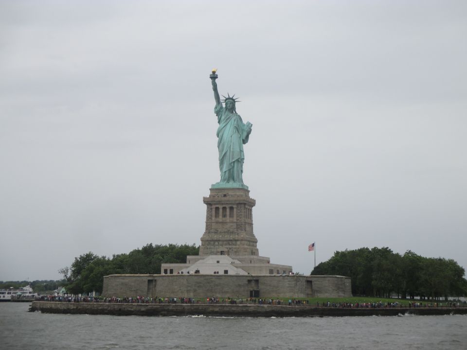 Statue of Liberty on Liberty Island under a cloudy sky