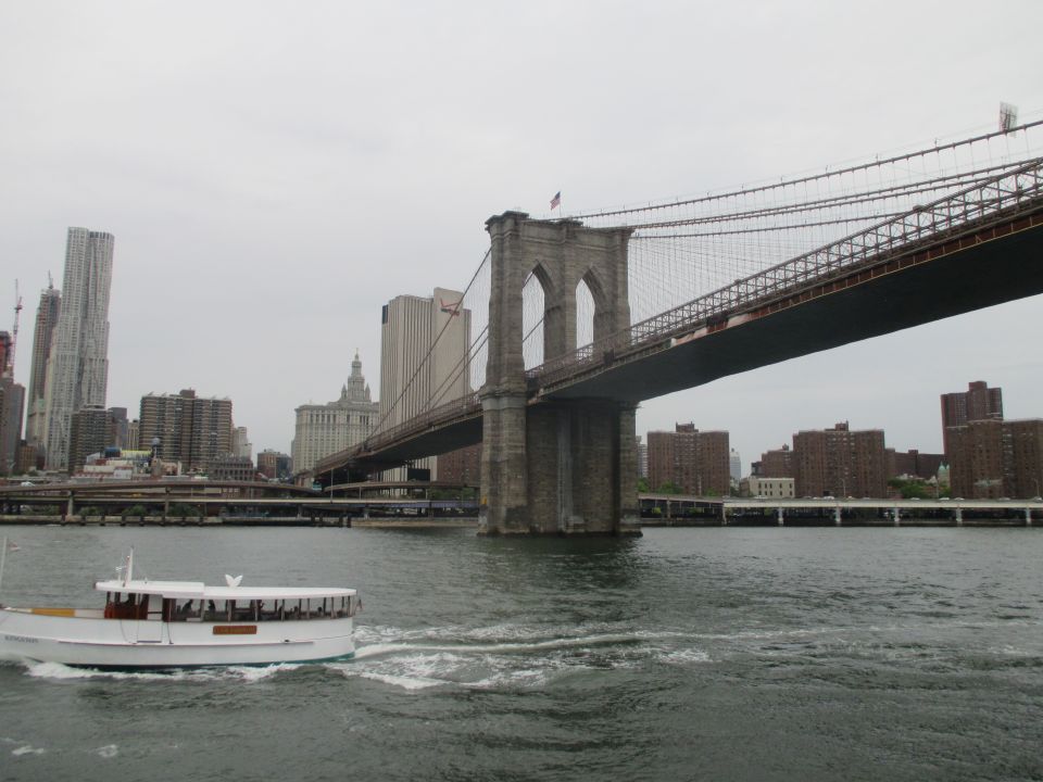 Brooklyn Bridge with a boat in the foreground on the water
