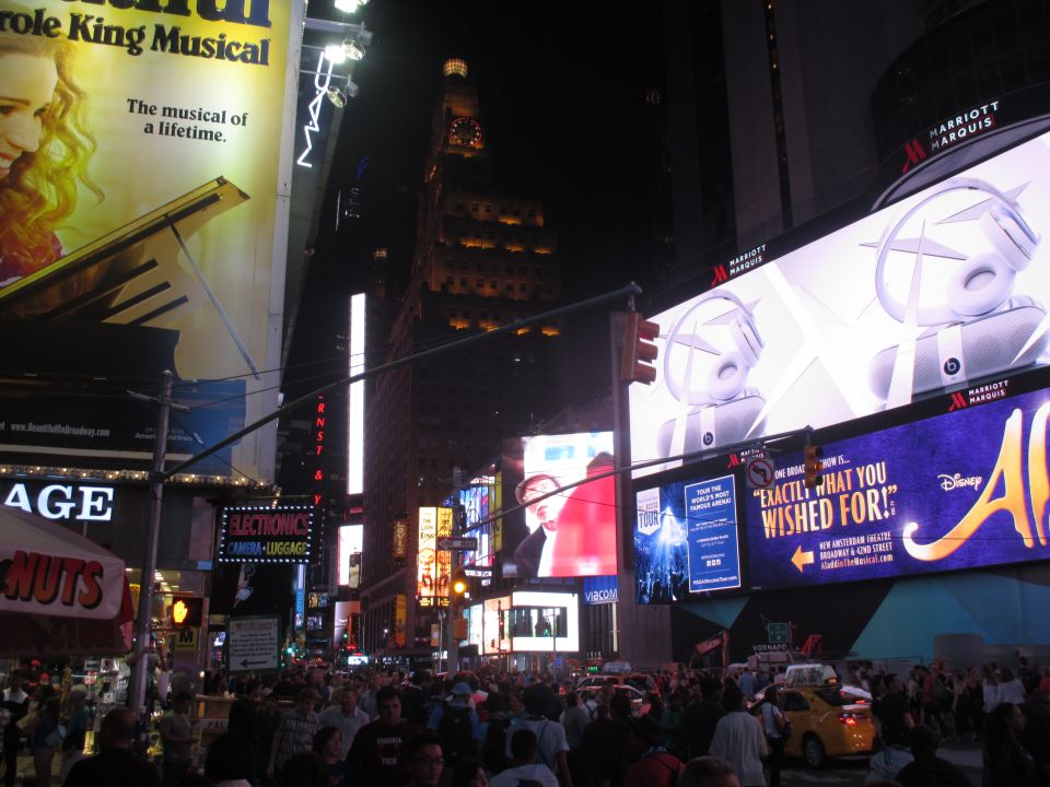 Times Square at night with bright billboards and crowds of people