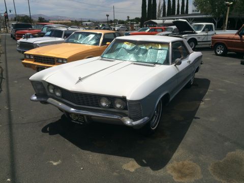 1968 Ford Mustang - A two-tone 1967 Buick Riviera is parked in a lot with other vehicles.