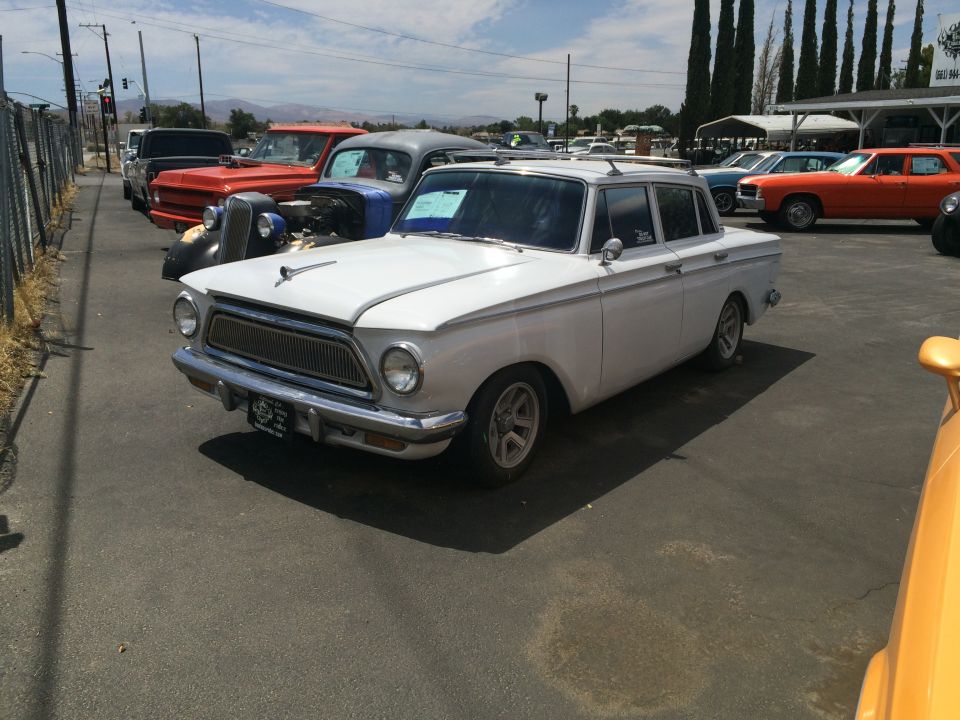 White sedan with chrome grille and trim parked in a lot with other vehicles