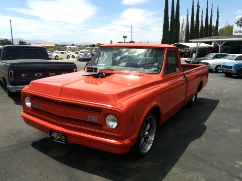 1968 Ford Mustang - This orange pickup truck has a prominent hood scoop and aftermarket wheels.