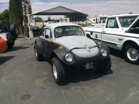 1968 Ford Mustang - A custom Volkswagen Beetle, modified for off-road use, sits in a lot with other vehicles under a covered structure.