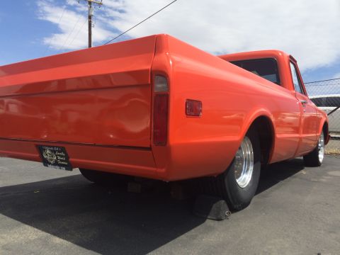 1968 Ford Mustang - Rear view of an orange pickup truck, possibly a 1967 model, with a custom license plate.