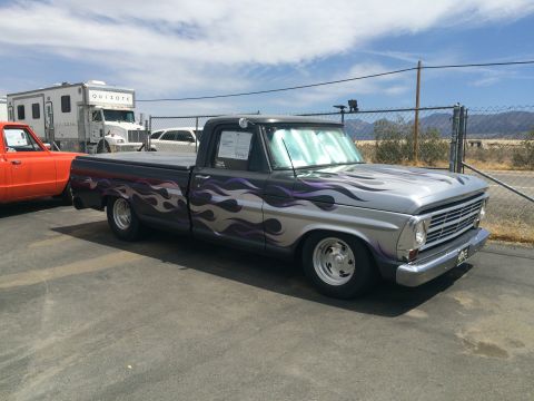 1968 Ford Mustang - This pickup truck has a two-tone paint job with purple and silver flames along the side.