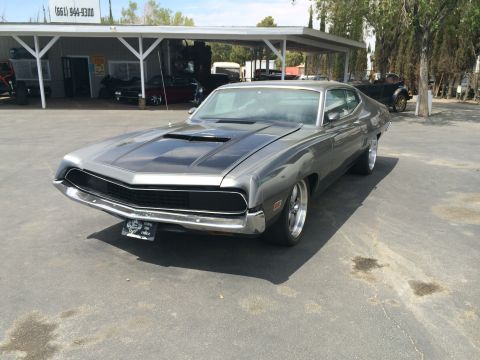 1968 Ford Mustang - Gray 1970 Ford Torino GT with black racing stripes on the hood.