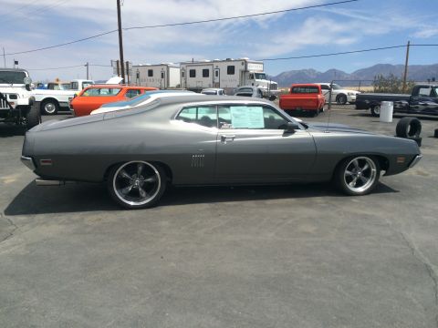 1968 Ford Mustang - A gray 1970 Ford Torino coupe is seen from the side in a lot with other vehicles and RVs.