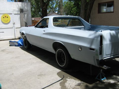 1973 Ford Ranchero - This pickup truck, likely a 1972 model, is in a state of repair with its body primed and rear end elevated on jack stands.