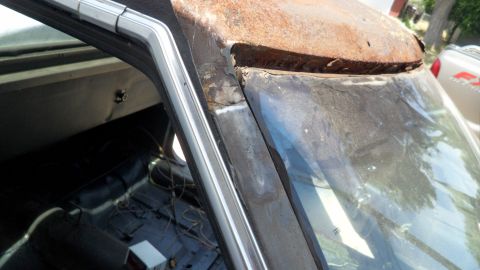 1972 Ford Ranchero - Close-up of a heavily rusted car roof and windshield frame, showing interior details.