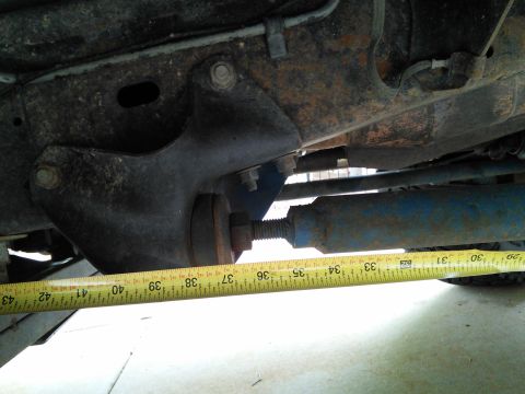 1996 Ford Bronco - Measuring suspension component under a vehicle, likely for modification or repair.