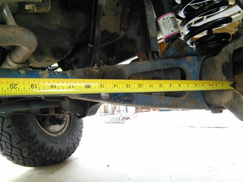 1996 Ford Bronco - Close-up of vehicle suspension components being measured, with a tire and coil spring visible.
