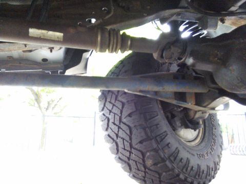 1996 Ford Bronco - Close-up view of the underside of a vehicle, focusing on the drivetrain and suspension system.