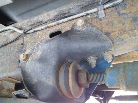 1996 Ford Bronco - Underside view of a vehicle's suspension system, showing a metal bracket and hardware.