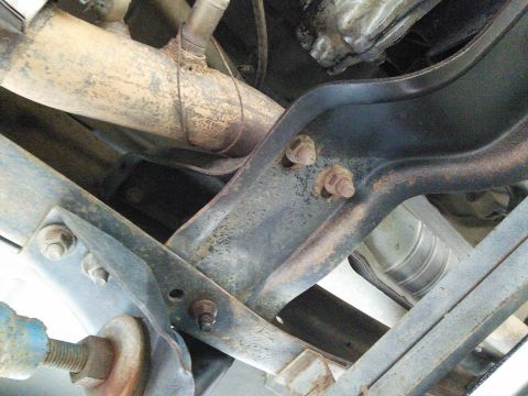 1996 Ford Bronco - Close-up view of the rusty undercarriage components of a vehicle, including exhaust and suspension parts.