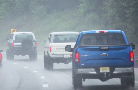 1979 Ford Bronco - Two Ford Broncos and a Ford F-150 are seen driving on a wet road during a rainstorm.