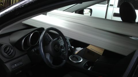 1994 Ford Bronco - Interior view of a car loaded with long items, with a white truck seen through the rear window.