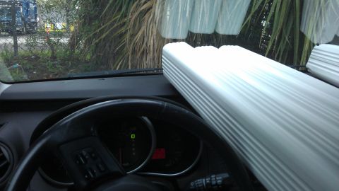 1994 Ford Bronco - The interior of a vehicle is visible, showing the dashboard, steering wheel, and a large white object obscuring the passenger side.