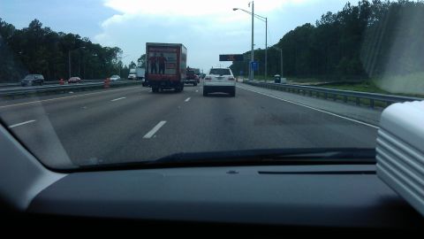 1994 Ford Bronco - Driving on a highway with multiple vehicles including a large truck and a white SUV.