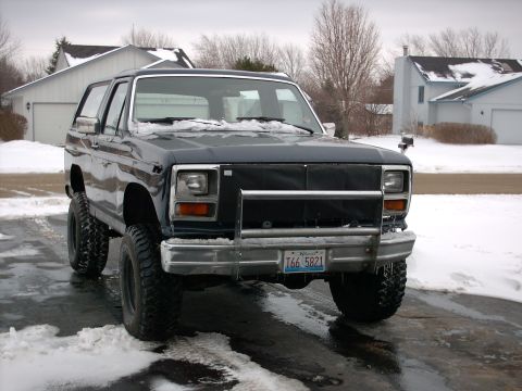 1986 Ford Bronco - This SUV, likely from the early 1980s, is equipped with a brush guard and lifted suspension, seen here in a snowy environment.
