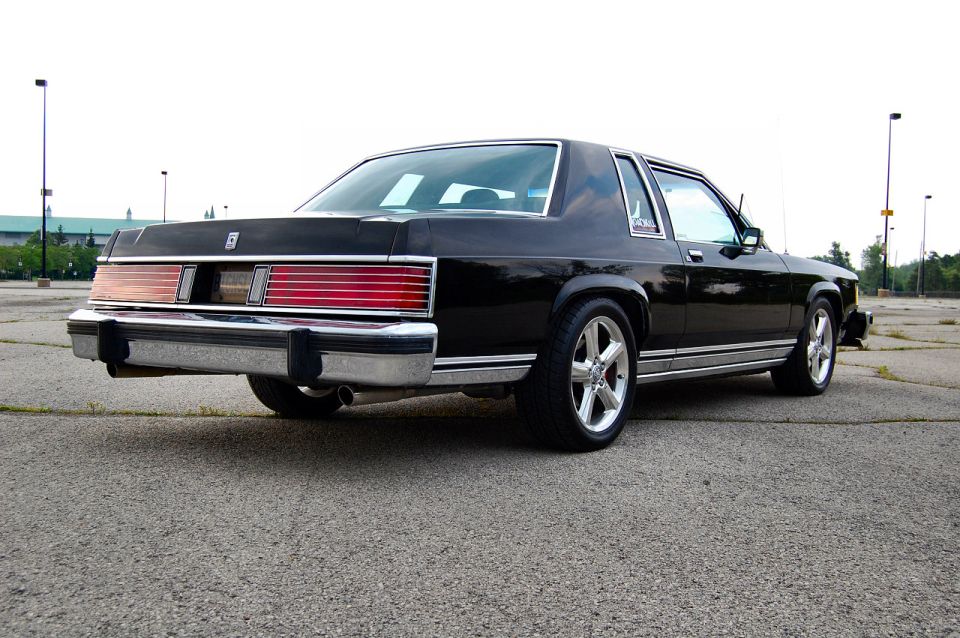 Black 1985 Mercury Grand Marquis, rear 3/4 view, parked on asphalt