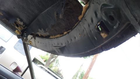 1972 Ford Ranchero - The underside of a vehicle's body panel shows damage and exposed insulation.