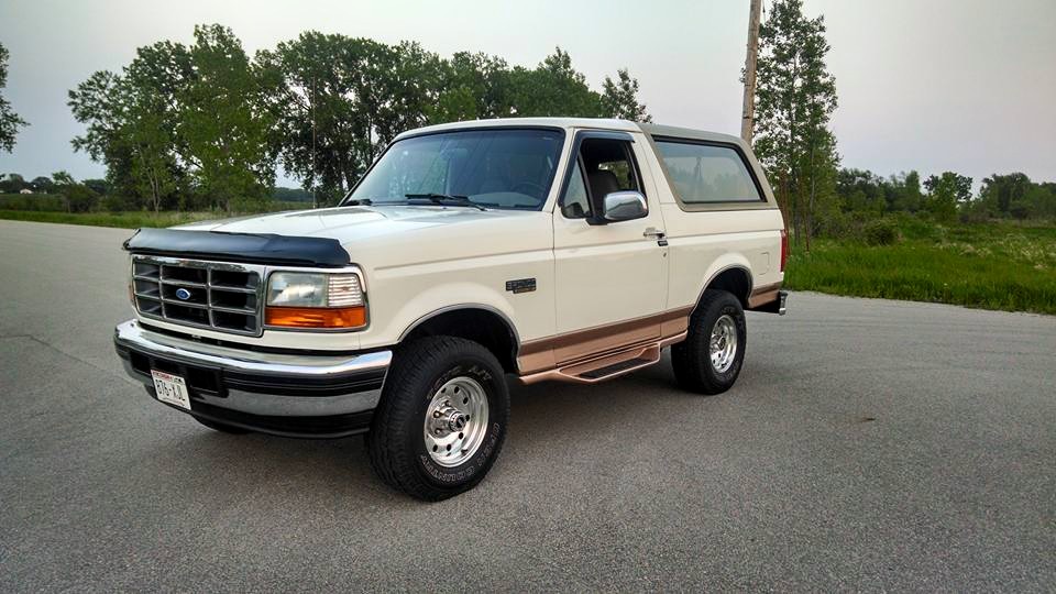 White 1994 Ford Bronco 3/4 front view with brown trim and running boards