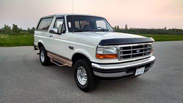 1994 Ford Bronco - White 1994 Ford Bronco with chrome accents and a black bug deflector on the hood.