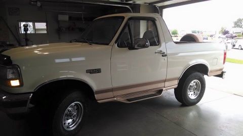 1994 Ford Bronco - This 1994 Ford Bronco is parked inside a garage, with its spare tire visible in the bed.