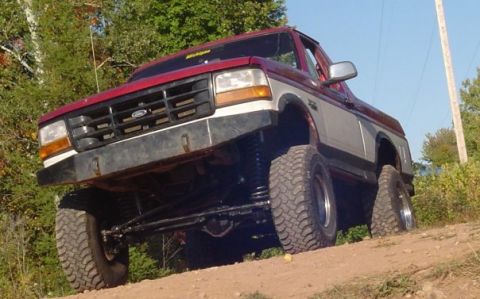 1994 Ford Bronco - This lifted 1994 Ford Bronco is shown in a three-quarter front view, highlighting its off-road modifications.