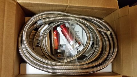 2003 Ford Crown Victoria - Coiled braided stainless steel hose lines and packaged fittings sit inside an open cardboard box.