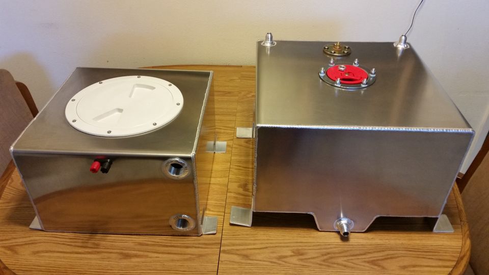 Two aluminum fuel cells with caps sitting on a wooden table