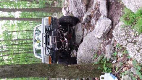 1979 Ford Bronco - This modified Ford F-150 Bronco is shown off-roading through a rocky forest trail.