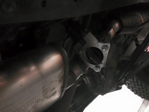 1995 Ford Bronco - A close-up view of a vehicle's exhaust system, focusing on a flange and muffler component.