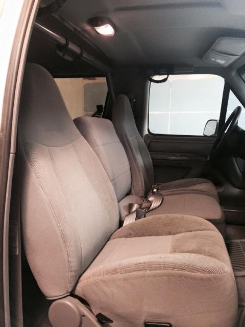 1995 Ford Bronco - The interior of a 1995 Ford Bronco shows grey cloth seats and seatbelts.