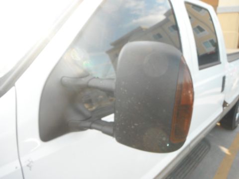 2000 Ford F-250 - Side view of a white pickup truck, focusing on the side mirror and door panel. The vehicle appears to be a 2000 Ford F-250.