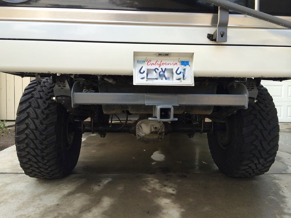 Rear view of lifted SUV with large tires, trailer hitch, and California license plate