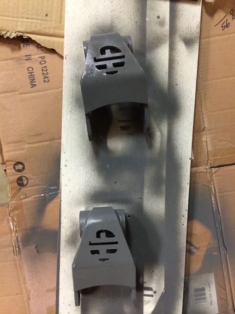 1995 Ford Bronco - Painted suspension parts with a logo are shown on a workbench.