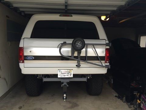 1995 Ford Bronco - Rear view of a white Ford Bronco with a black stripe and external spare tire mount.