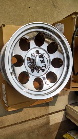 1994 Ford Bronco - A single chrome wheel with a "M/T" logo is shown, resting on cardboard boxes.