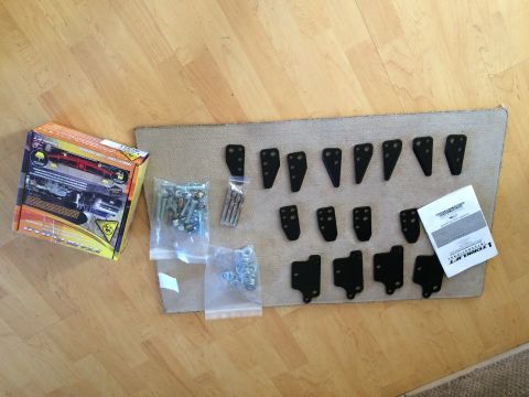1997 Dodge 3500 - This image displays a collection of vehicle parts and hardware, including a product box and various fasteners, laid out on a wooden floor.
