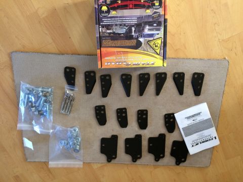 1997 Dodge 3500 - This image shows a kit of parts for Stable Load, including various brackets, bolts, nuts, and drill bits, along with the product box and in…