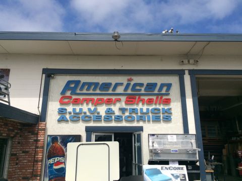 1997 Dodge 3500 - The storefront for American Camper Shells S.U.V. & Truck Accessories displays various truck accessories and a large Pepsi advertisement.