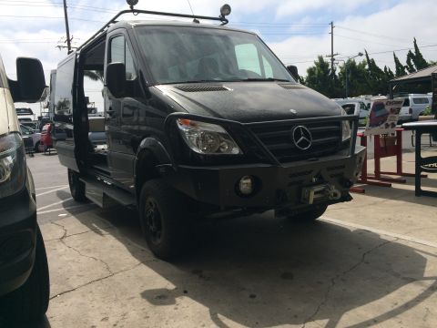 1997 Dodge 3500 - This black Mercedes-Benz Sprinter van features a heavy-duty custom bumper with a winch and a roof rack with auxiliary lights.