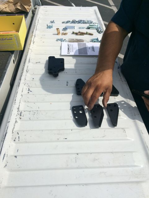 1997 Dodge 3500 - Parts and hardware for Stable Load are arranged on a white truck bed.